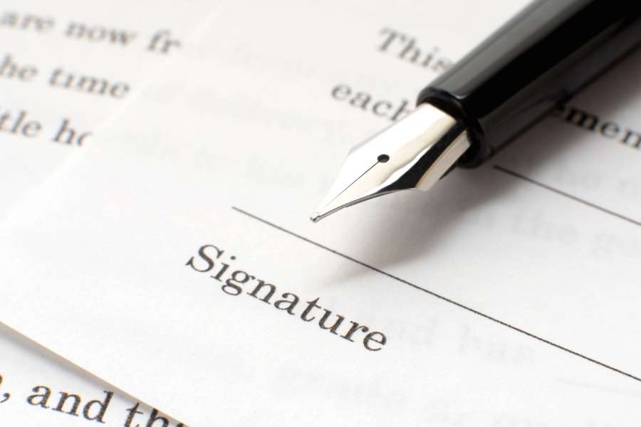 Un stylo plume posé sur une ligne de signature d'un document officiel.